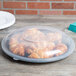A Fineline black plastic catering tray with croissants on it.