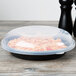 A clear plastic Fineline high dome lid on a bowl of spaghetti.