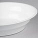 A white Fineline low profile plastic catering bowl on a gray surface.