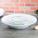 A white plastic Fineline low profile catering bowl with a lid on it.