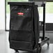 A black Rubbermaid housekeeping cart bag on a cart.