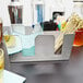 An American Metalcraft stainless steel hammered finish bar caddy on a table with a bottle and glass of liquor inside.