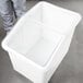 A person opening a white plastic container with a clear lid.