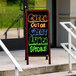 A cherry A-frame sign board with a black write-on acrylic marker board on a sidewalk.