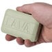 A person holding a green Lava bar soap.