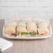 A clear Eco-Products plastic lid on a tray of sandwiches.