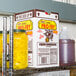 A plastic jug of Admiration Pro Fry Liquid Shortening with a white cap on a shelf next to a box of food and a jar of yellow mustard.
