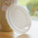 A close-up of a white Eco-Products compostable plastic hot cup lid.