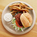A Eco-Products wheat straw compostable plate with a burger and fries on it.