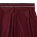 A burgundy Snap Drape table skirt with white stitching.