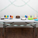 A table with Fresh Mint Green streamers, plates, and cups on it.
