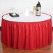 A table with a red Snap Drape table skirt on it.