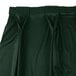 A close up of a dark green Snap Drape Wyndham bow tie pleat table skirt with velcro clips.