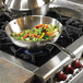 a pan with vegetables on top of a stove