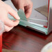 A person cutting a Eco-Products GreenStripe compostable plastic straw.