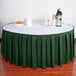 A table with a green Snap Drape Wyndham table skirt on it.