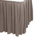 A Snap Drape Wyndham gray table skirt with pleated edges.