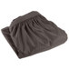 A folded charcoal table skirt with pleats.