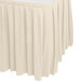 A bone colored Snap Drape box pleat table skirt with Velcro clips on a table.