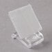 A clear plastic table skirt clip with a white surface.