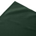 A dark green Snap Drape shirred pleat table skirt with a folded edge.