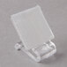 A clear plastic holder with a white square sitting on a stand.