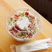 A clear Eco-Products plastic container with salad and a fork.