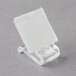 A clear plastic holder with a white square inside.