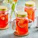 Three Acopa Rustic Charm mason jars filled with lemonade and lemon slices.