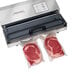 A Hamilton Beach NutriFresh vacuum packaging machine sealing meat in bags.