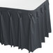 A slate blue Snap Drape table skirt with bow tie pleats on a table.