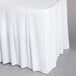 A white Snap Drape table skirt with velcro clips over a white tablecloth.