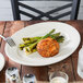 An ivory oval china platter with meatballs and asparagus on it.