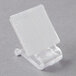 A clear plastic Velcro clip for a table skirt on a white square.