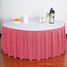 A table with a Snap Drape dusty rose box pleat table skirt on it.