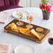 An American Metalcraft carbonized bamboo pairing flight board with cheese and wine on a table.