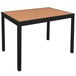 A black aluminum bar height table with a synthetic teak top.