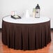 A table with a brown Snap Drape table skirt and a tray of drinks.