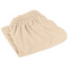 A folded beige table skirt on a white background.