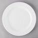 A Libbey Royal Rideau white porcelain plate with a white rim on a gray surface.