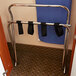 A chrome metal high back luggage rack with straps on it.