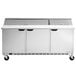 A stainless steel Beverage-Air commercial refrigerator with three doors and a cutting board.