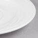 A Libbey white porcelain tea saucer with a white rim.
