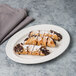 A chocolate covered pastry on a Libbey white porcelain platter.