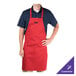 A man wearing a red Chef Revival bib apron with a customized name embroidered on it.