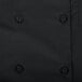 A close up of a black Chef Revival short sleeve chef coat with buttons.