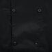 A close up of a black Chef Revival long sleeve chef jacket with buttons.