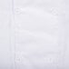 A close up of a white Chef Revival short sleeve chef jacket with buttons.
