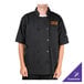 A person wearing a black Chef Revival short sleeve chef coat with an orange logo.