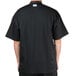 A man wearing a black Chef Revival short sleeve chef jacket with mesh back.